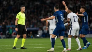 Árbitro observando una jugada polémica por mano durante un partido de fútbol
